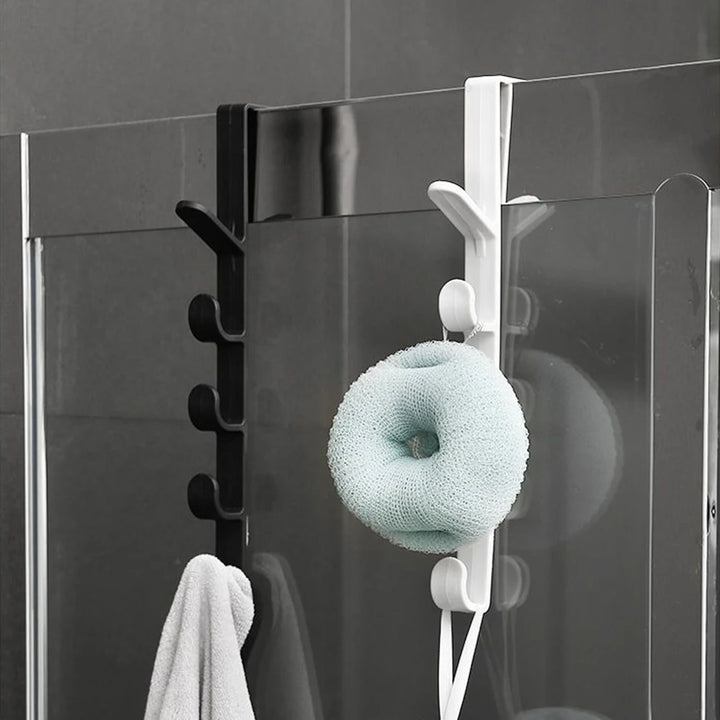 Porte manteau suspendu noir et blanc fixé sur une porte en verre de salle de bain, parfait pour accrocher serviettes et accessoires