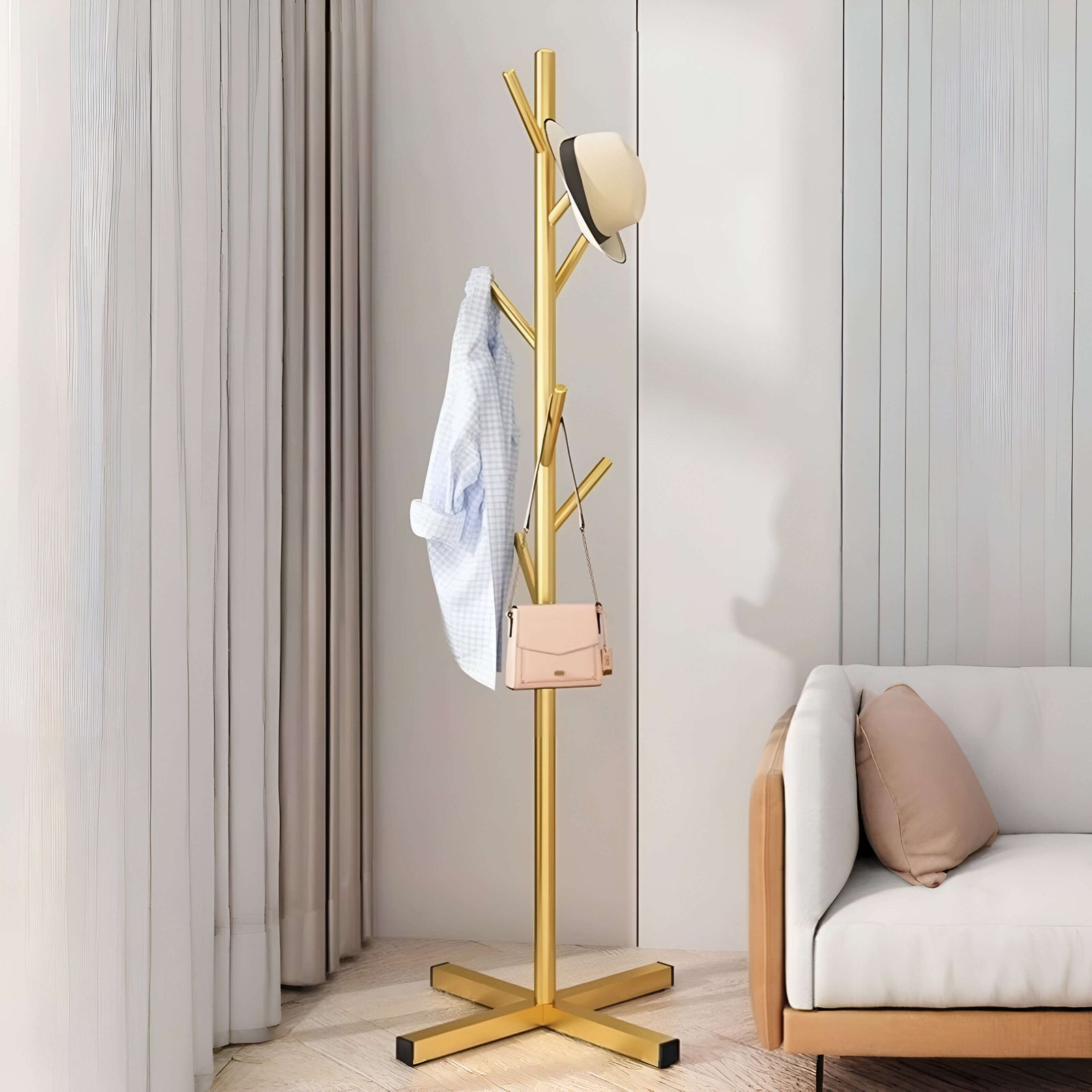 Porte-manteaux doré en métal, installé dans un salon moderne, parfait pour organiser manteaux et sacs avec style.