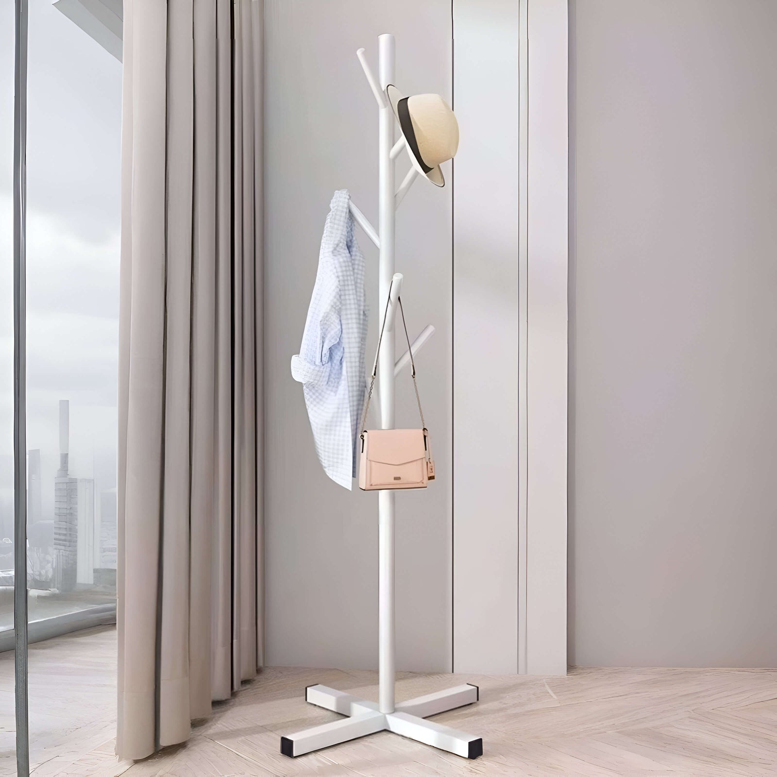 Porte-manteaux en métal blanc sur pied, au design moderne et minimaliste, idéal pour une maison contemporaine.